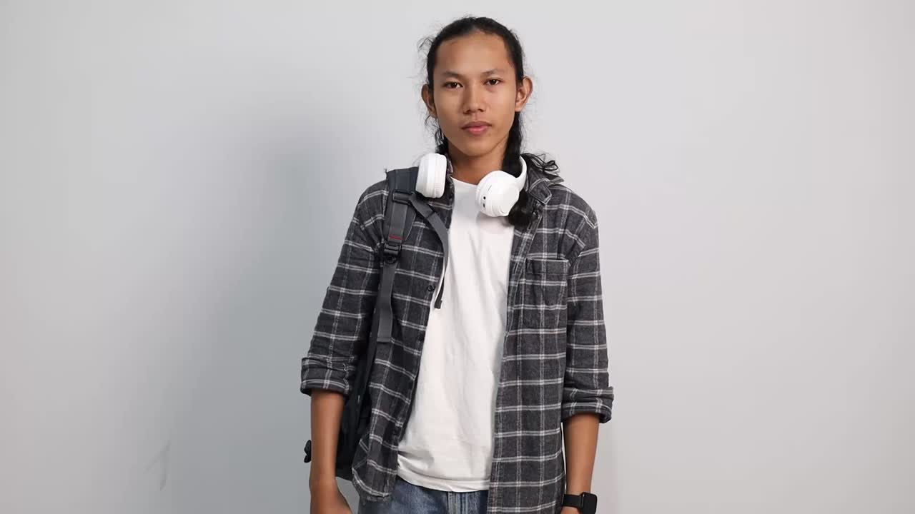 Young Asian college student having headache and massaging temples isolated on white studio background
