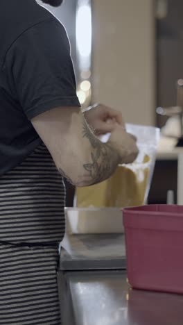 person pouring ingredients in a kitchen