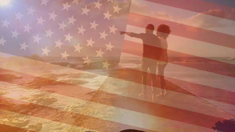 animation of flag of united states of america over couple walking on beach