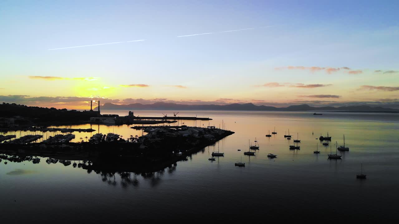 aerial drone shot of a dark port just as the sun rises panning right