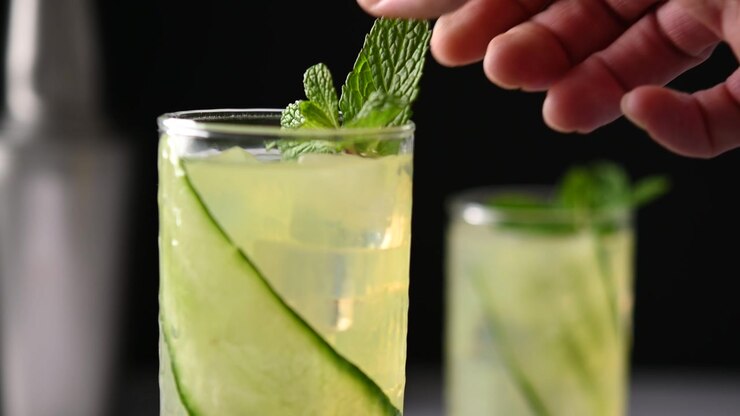 Barman che posiziona una foglia di menta fresca su un cocktail English Garden, primo piano