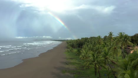 beautiful drone shot of a rainbow over a beach on a tropical paradise island