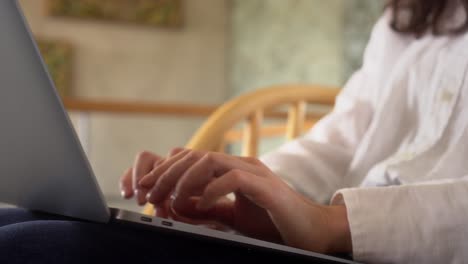 escena de primer plano de una mujer de negocios escribiendo en una computadora portátil trabajando desde casa, usando tecnología haciendo trabajo remoto en línea en casa