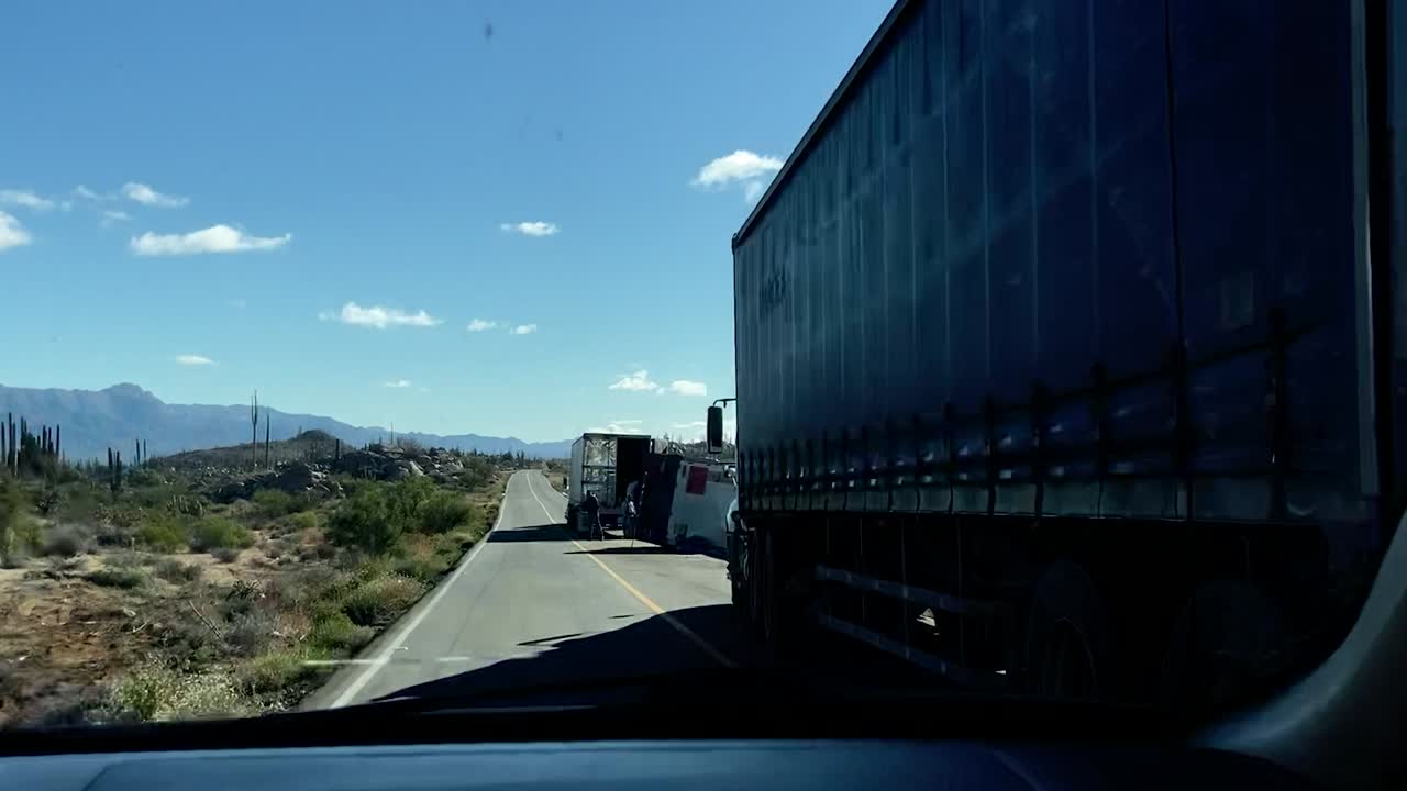 파손 된 반 트럭 이 뒤집혀 사막 도로 의 교통 을 늦추고 있다