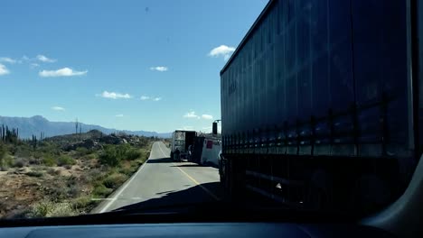 un camión destrozado y volcado ralentiza el tráfico en la carretera del desierto.