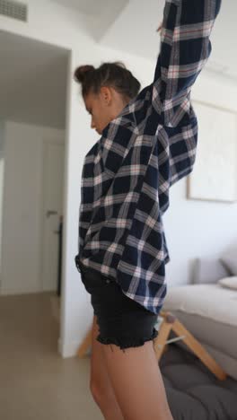 woman posing in plaid shirt and shorts