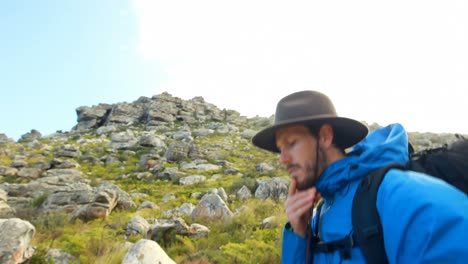 excursionista masculino caminando con mochila en el campo 4k