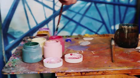 artista pintor a mano mezcla pintura cerca se encuentra un frasco de pintura