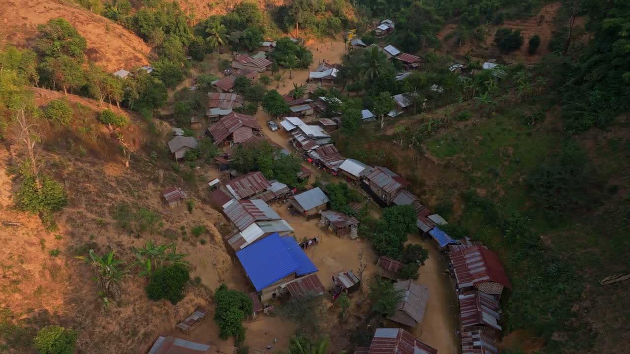 Traditional hill tribe houses surrounded by dense greenery, Thailand
