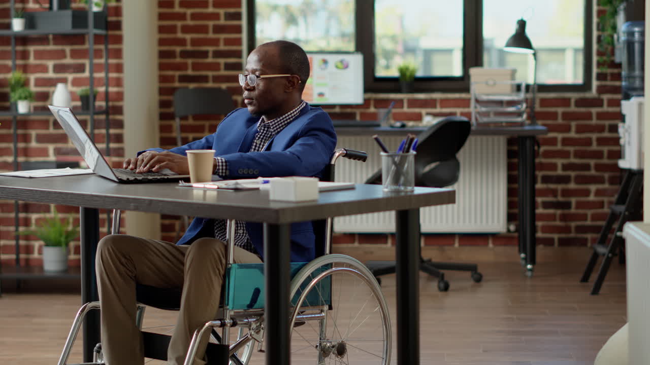Lavoratore paralizzato con disabilità fisica che analizza statistiche