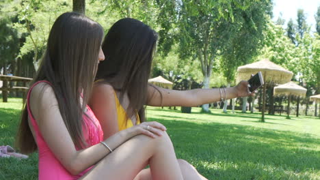 two women taking a selfie in a park