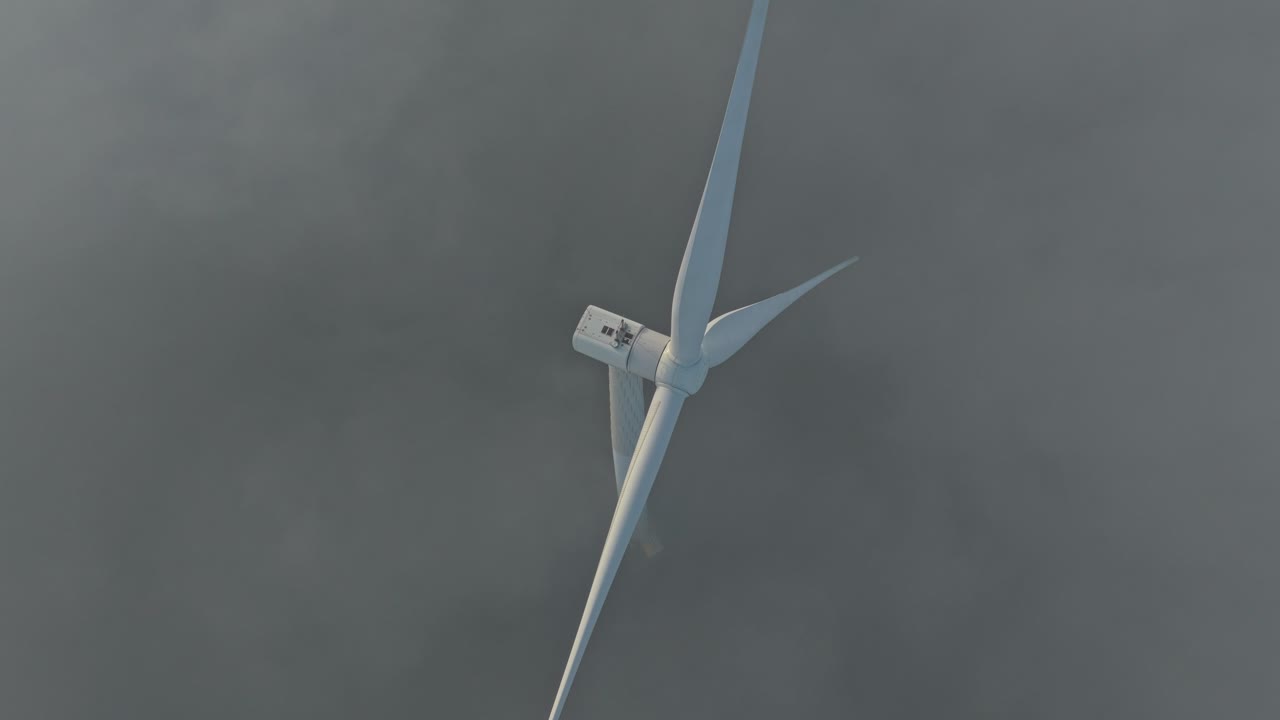 Wind turbine rotating generating electricity in foggy weather