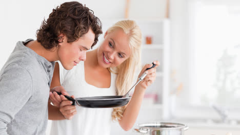 una pareja caucásica sonriente preparando comida juntos en la cocina de casa