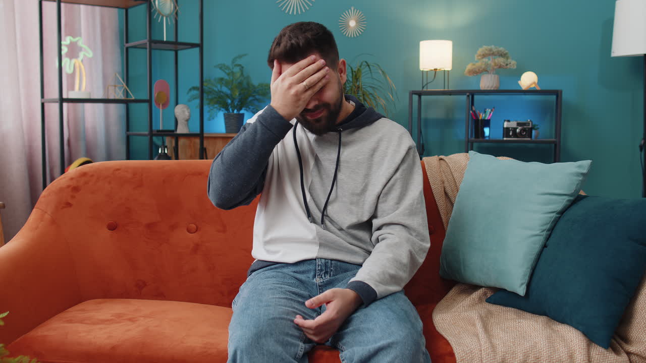 Young man raising hands asking what why reason of failure disbelief irritation by troubles at home