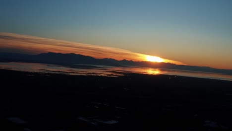 gorgeous aerial drone view of utah lake during a golden sunset on a warm fall evening in provo