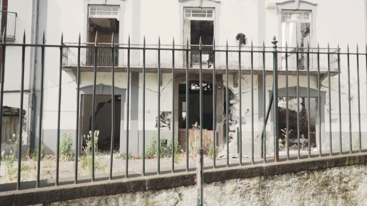 edificio dañado detrás de una valla