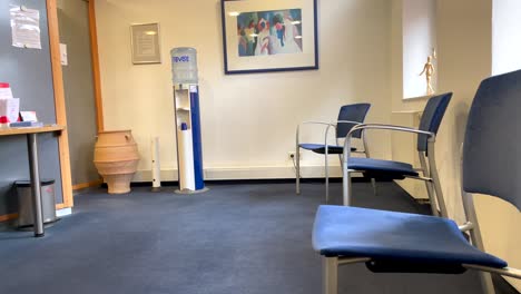 Empty-waiting-room-at-doctor-office-with-chairs,soda-fountain-and-sunlight