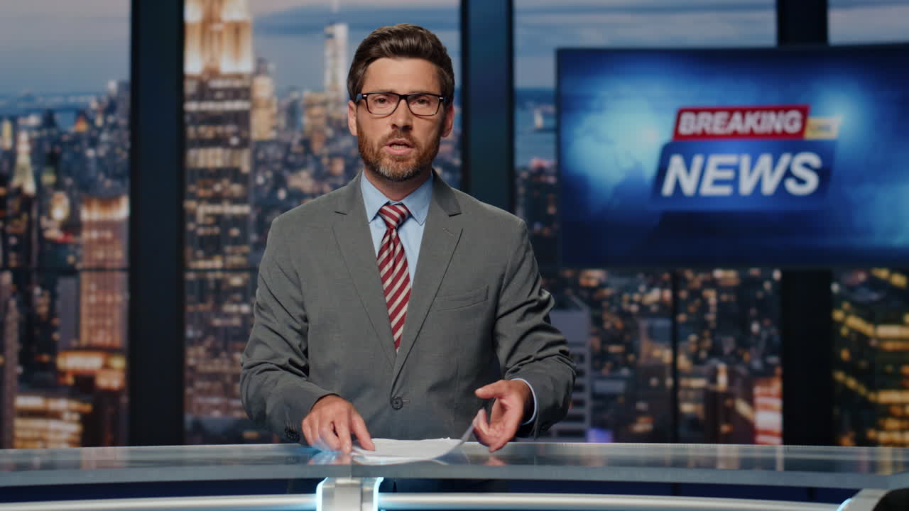 Bearded newscaster ending program in evening newsroom studio. Late breaking news