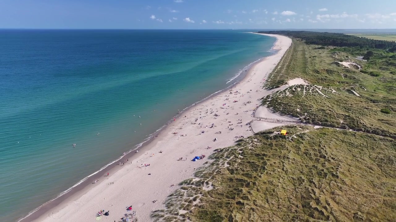 Travl Curracloe Strand med folk der slapper af ved turkist hav på en solrig irsk sommerdag