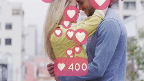 animación de iconos de corazón flotando sobre una feliz pareja caucásica abrazándose
