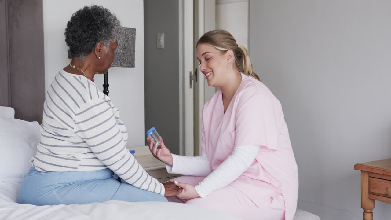 Caucasian female nurse talking to senior african american woman, copy space, slow motion