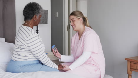 caucasian female nurse talking to senior african american woman, copy space, slow motion