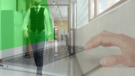 animation of hands using laptop over businessman walking in office corridor