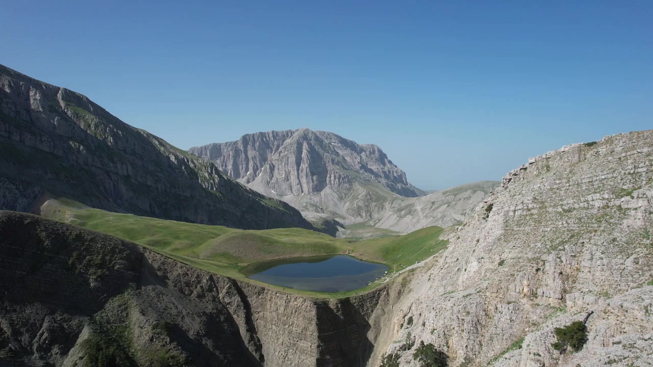 Riprese aeree con drone che mostrano il Monte Tymfi e il Lago del Drago (Drakolimni), nella catena montuosa del Pindo settentrionale della Grecia nord-occidentale.