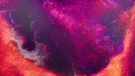 macro view of pink glitter ink being forcefully propelled into orange pigment, creating a dynamic circular splash