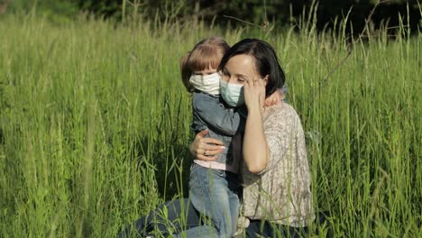 family in park takes off medical masks after coronavirus pandemic quarantine end