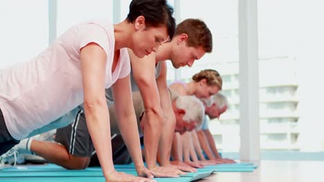 clase de ejercicios haciendo flexiones juntos