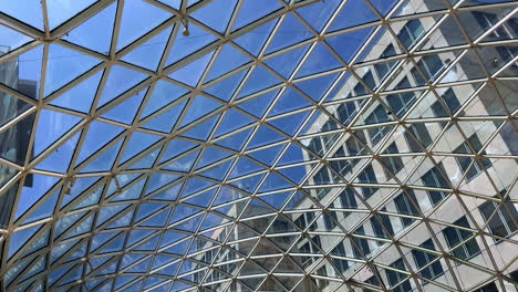 glass cupola of the building with the view on the blue sky. low angle perspective on the buildings outside