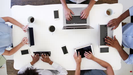 grupo trabajando en computadoras con teléfonos, disparo aéreo