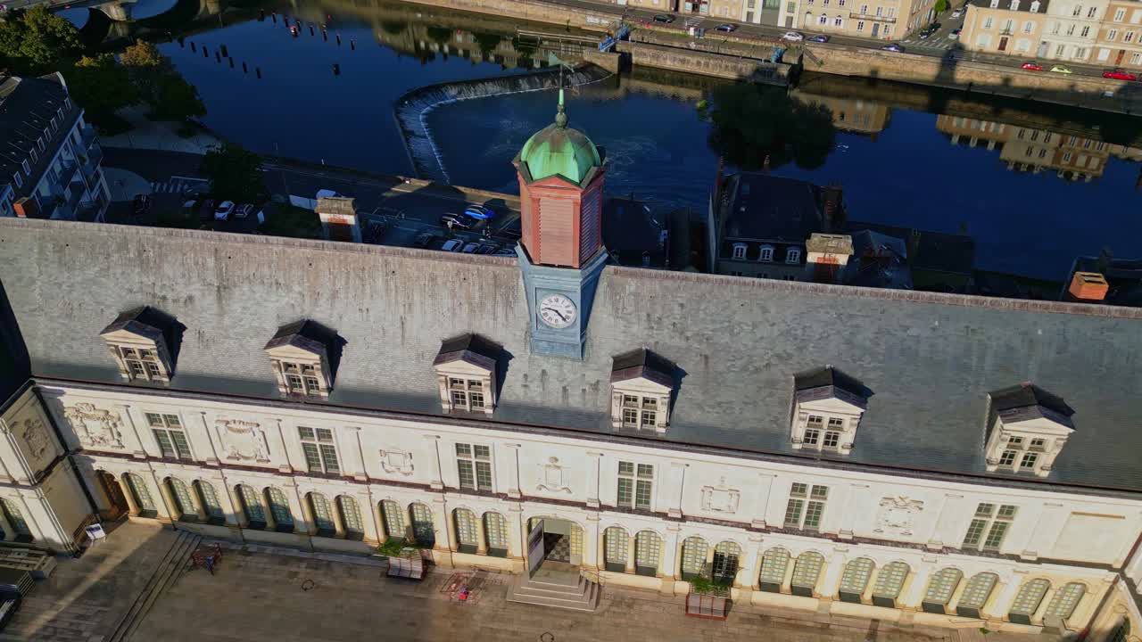 Clock tower on Château-Neuf castle, historic architecture, Mayenne river, and Laval cityscape at golden hour. Aerial approach