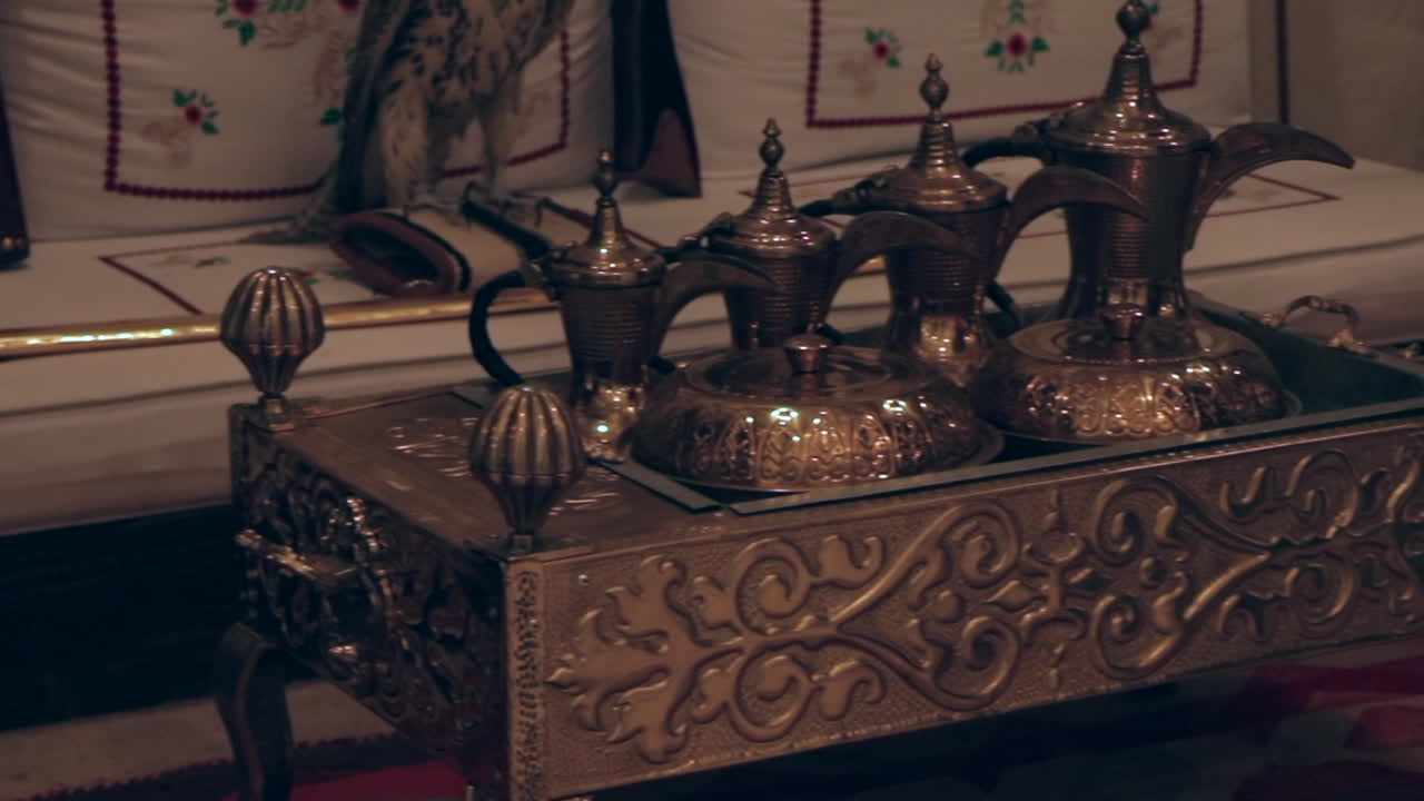 A beautiful panning shot of an Arab teapoe with old mugs and jugs representing the arab culture.
