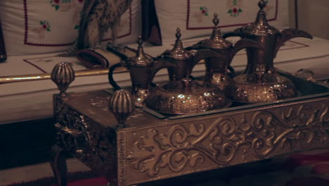 a beautiful panning shot of an arab teapoe with old mugs and jugs representing the arab culture.