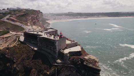 faro rojo de nazare o nazaré y la costa del golfo en el fondo