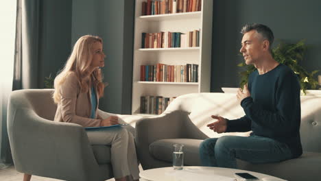 male patient in the consultation of a female psychiatrist who takes note of his mental health diagnosis