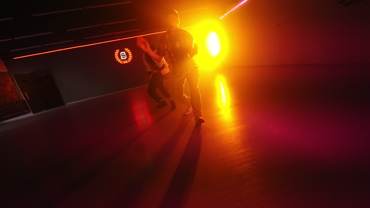 Modern hip hop style dancers moving rhythmically. Dance studio performers at the backdrop of projector.