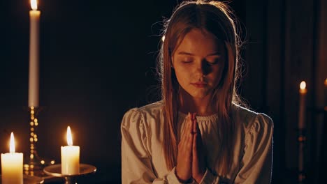 chica orando frente a las velas