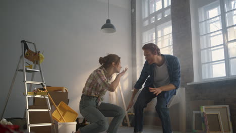 Married-woman-and-man-relaxing-in-new-apartment.-House-renovation-concept.