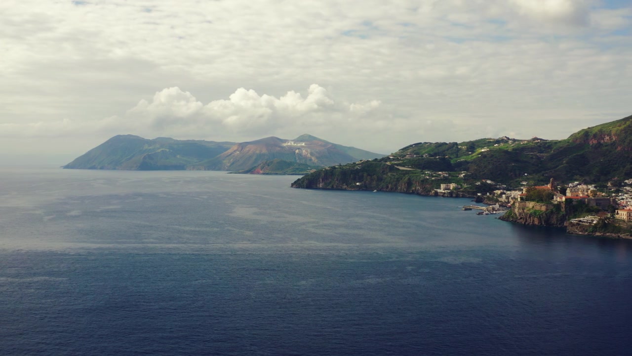 Panorama aéreo de la Isla de Lipari con la isla de Vulcano visible a lo lejos, Sicilia, Islas Eolias. Toma de paisaje costero.