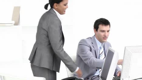 businesswoman and businessman looking at a computer