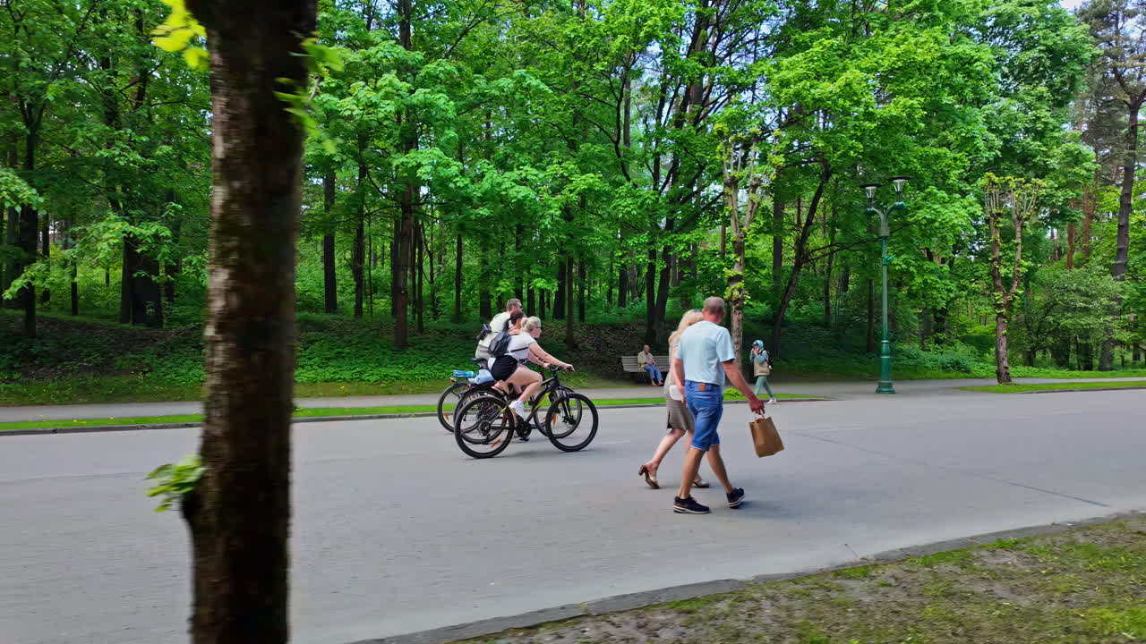 People walking and cycling in a lush green park