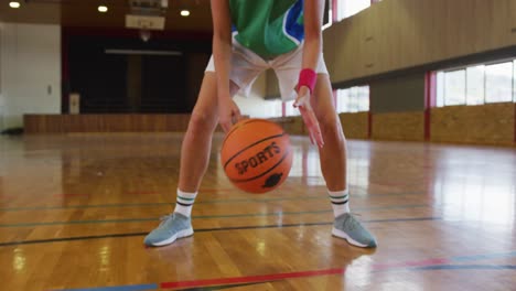 Mittelteil-Einer-Afroamerikanischen-Basketballspielerin,-Die-Den-Ball-Dribbelt