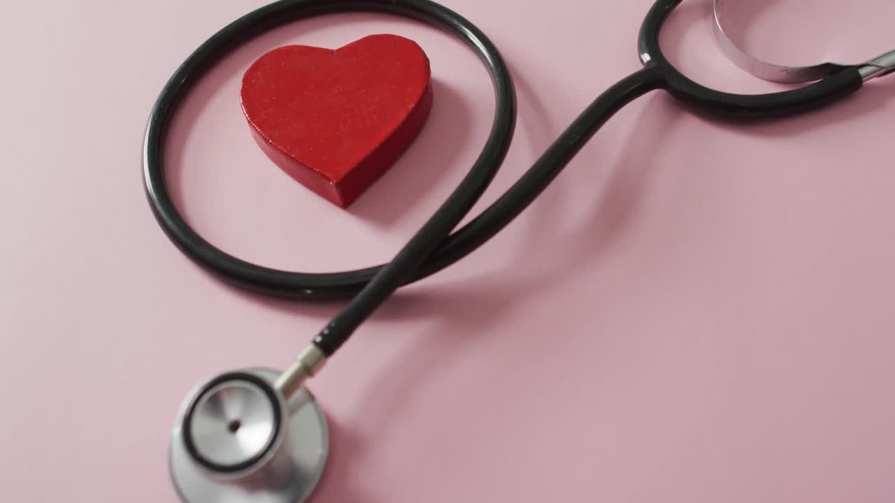 Stethoscope and red heart on pink background at valentine's day