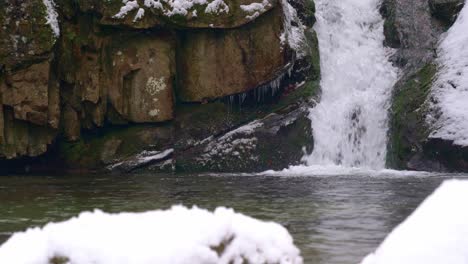 Impresionante-Cascada-En-Un-Paisaje-Cubierto-De-Nieve-Mientras-Nieva-En-Invierno,-Tiro-Estático