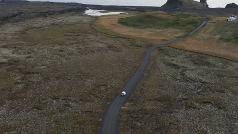 car drives on remote road in volcanic landscape towards edge of reykjanes peninsula