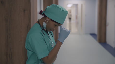 una joven doctora estadounidense se toma un descanso del estrés en un pasillo del hospital