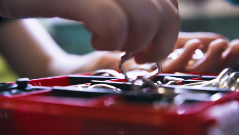 skilled tailor takes silver buckles from red box section